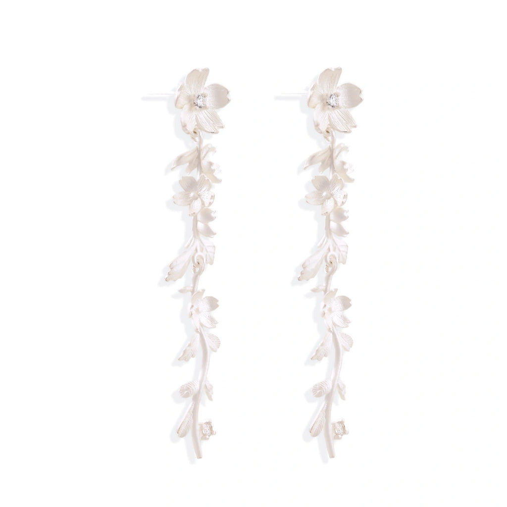 Long sterling silver drop earrings with delicate floral vine design and crystal accents on white background
