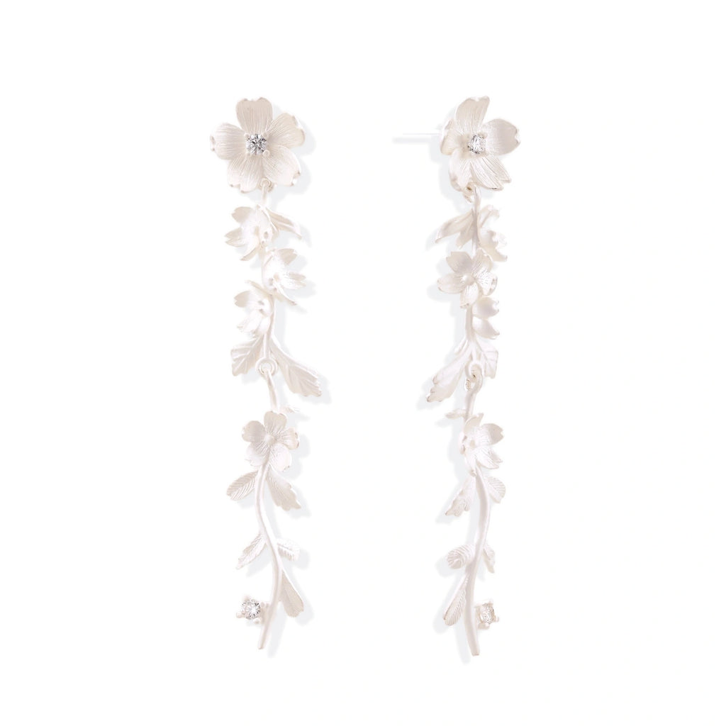 Long sterling silver drop earrings with delicate floral vine design and crystal accents on white background