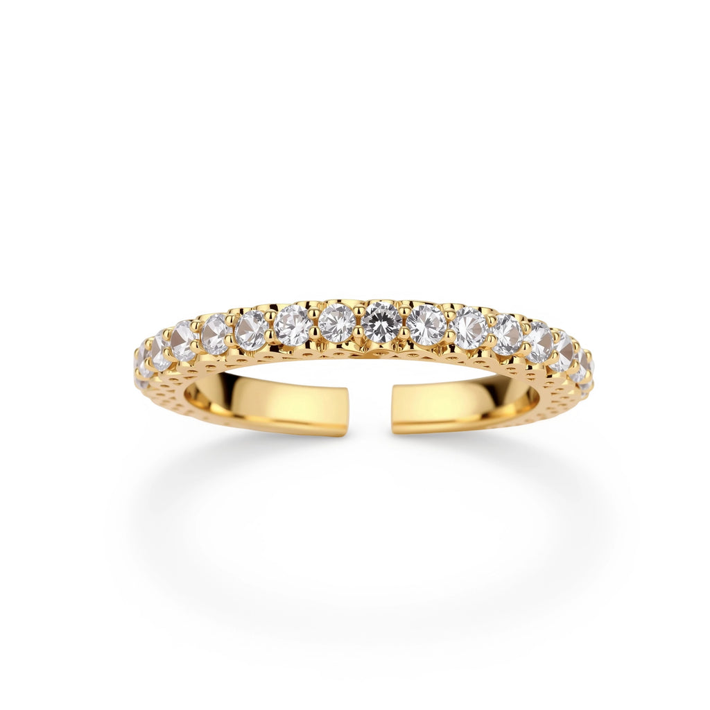 Close-up of adjustable gold-plated ring with continuous row of round zirconia stones on neutral background.
