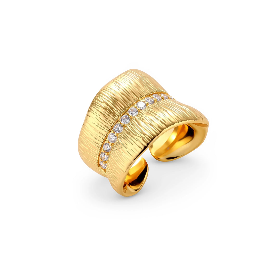 Adjustable gold-plated cuff ring with parallel ridged texture and diagonal row of sparkling zirconia stones on white background.