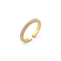 Close-up of adjustable gold-plated ring with continuous row of round zirconia stones on neutral background.